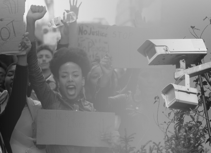 Image Description: A photo of a Black woman raising her first at a protest fades into a photo of a police surveillance camera.