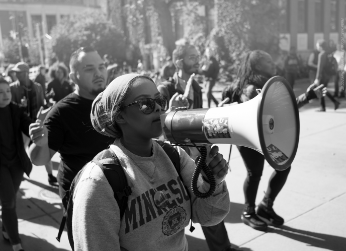 Black woman holds megaphone at protest.